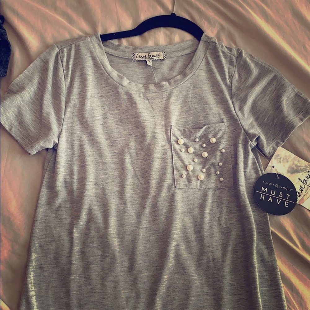 a gray shirt with pearls on front pocket